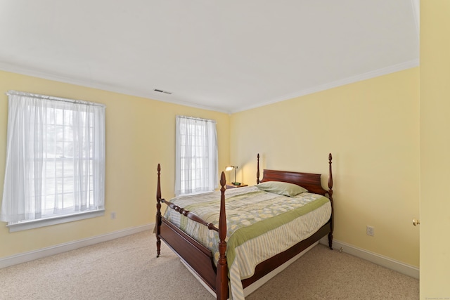 carpeted bedroom featuring crown molding, baseboards, and visible vents