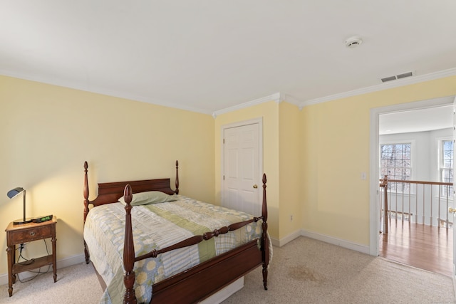 bedroom with light colored carpet, baseboards, ornamental molding, and visible vents