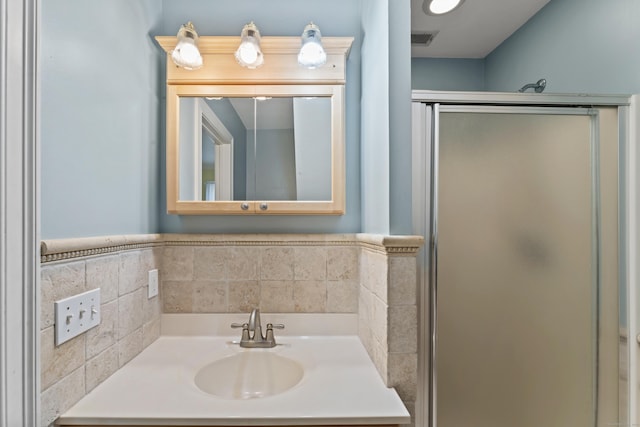 full bath with a shower stall, vanity, and visible vents