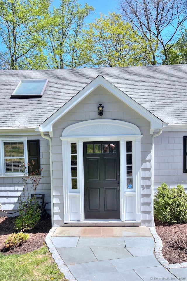 doorway to property featuring a shingled roof