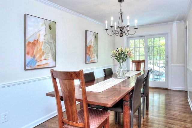 dining room with crown molding, dark wood-type flooring, and a notable chandelier