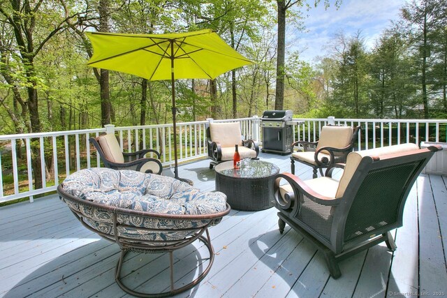 wooden terrace featuring an outdoor living space and grilling area