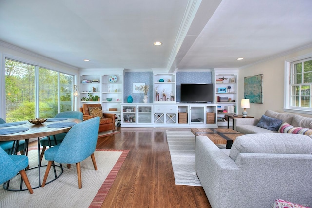 living room featuring built in shelves, ornamental molding, recessed lighting, and dark wood-type flooring
