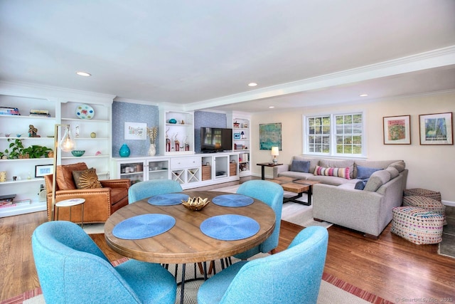 dining area featuring built in shelves, crown molding, recessed lighting, and wood finished floors