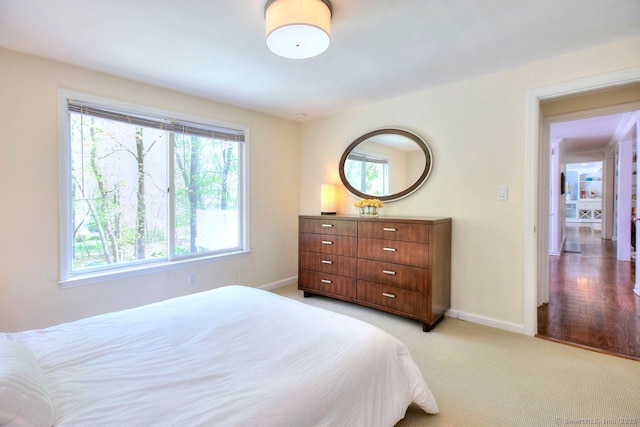 bedroom with light carpet and baseboards