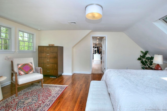 bedroom featuring visible vents, wood finished floors, and lofted ceiling