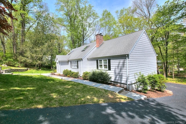 view of front facade featuring a chimney and a front lawn