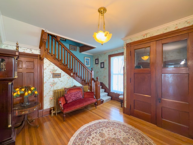 1063 Main St, South Windsor, CT 06074 - foyer entrance with wallpapered walls, wood finished floors, stairs, radiator, and ornamental molding