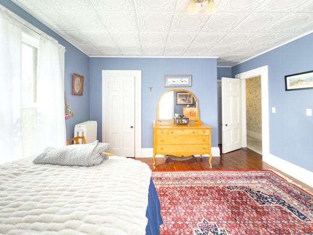 1063 Main St, South Windsor, CT 06074 - bedroom featuring radiator, dark wood-style flooring, and an ornate ceiling