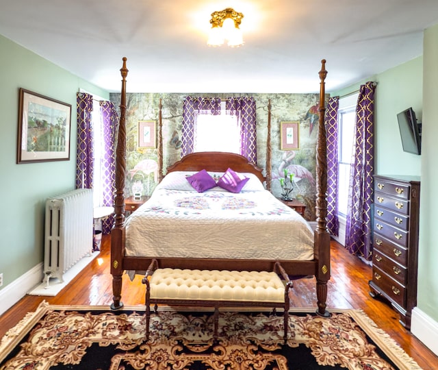 1063 Main St, South Windsor, CT 06074 - bedroom with radiator heating unit, multiple windows, and wood finished floors