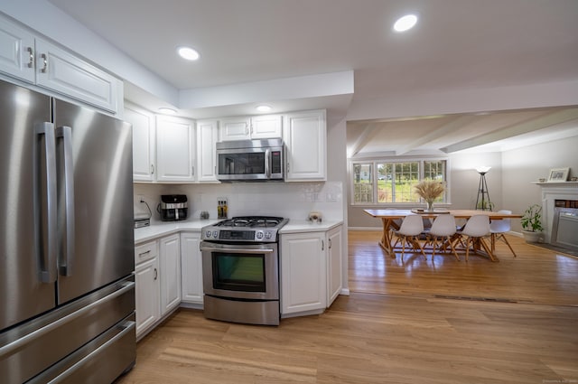 125 Northford Rd, Branford, CT 06405 - kitchen with light wood-style floors, light countertops, stainless steel appliances, white cabinetry, and backsplash