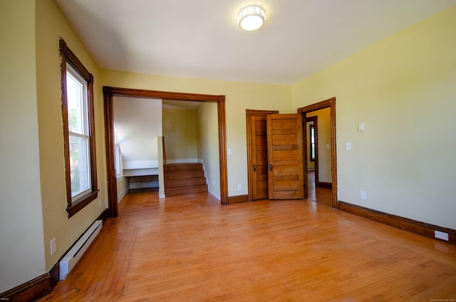 93 Broad St, Norwich, CT 06360 - unfurnished room featuring a baseboard radiator, light wood-style flooring, baseboards, and stairway