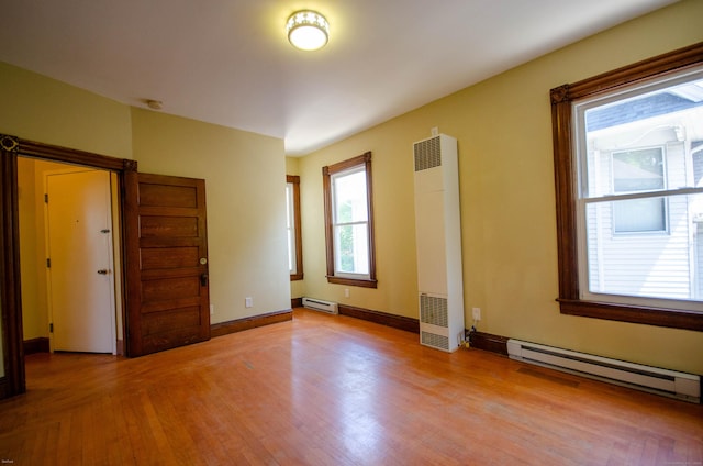 93 Broad St, Norwich, CT 06360 - empty room with a heating unit, a baseboard heating unit, and light wood-type flooring