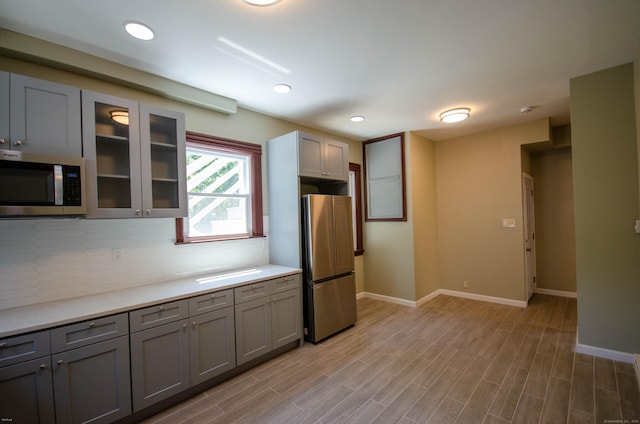 93 Broad St, Norwich, CT 06360 - kitchen with stainless steel appliances, gray cabinetry, backsplash, light countertops, and recessed lighting