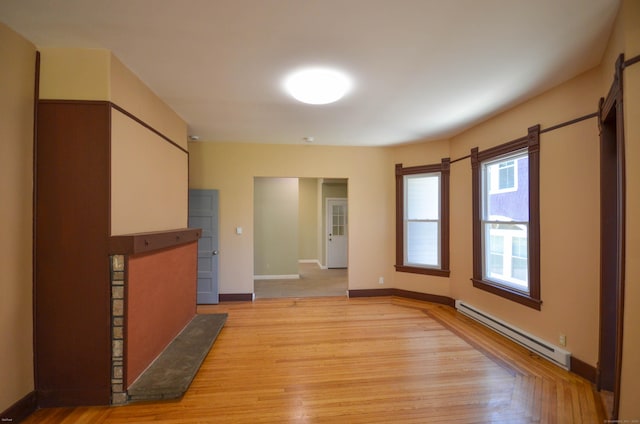 93 Broad St, Norwich, CT 06360 - unfurnished living room with baseboard heating, light wood-style floors, and baseboards