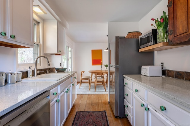 15 Echo St, Salisbury, CT 06068 - kitchen with appliances with stainless steel finishes, a sink, light wood-style flooring, white cabinetry, and light stone countertops