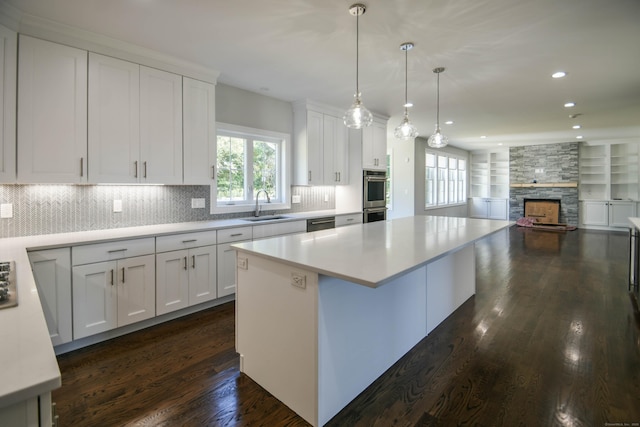 1481 Marion Rd, Cheshire, CT 06410 - kitchen with a sink, a fireplace, appliances with stainless steel finishes, a kitchen island, and white cabinetry