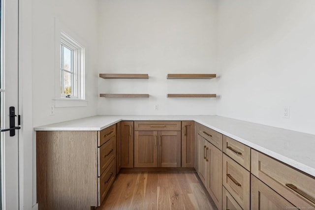 7 Egret Rd, Stonington, CT 06355 - kitchen with open shelves, light wood-type flooring, light countertops, and brown cabinets