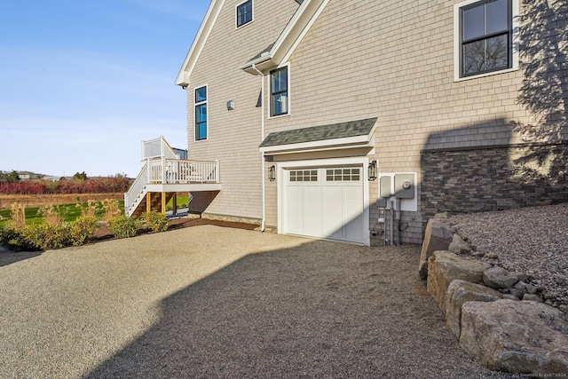 7 Egret Rd, Stonington, CT 06355 - view of side of home with stairs, an attached garage, asphalt driveway, a shingled roof, and a wooden deck