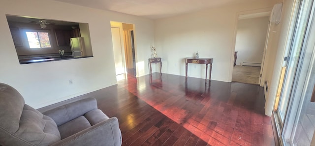 interior space featuring wood finished floors, a baseboard radiator, and ceiling fan