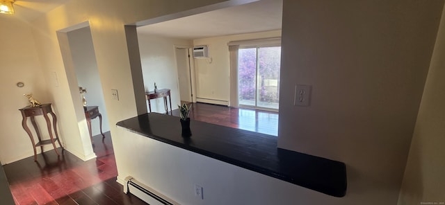 kitchen with a wall mounted air conditioner, dark wood-style floors, baseboard heating, baseboards, and dark countertops