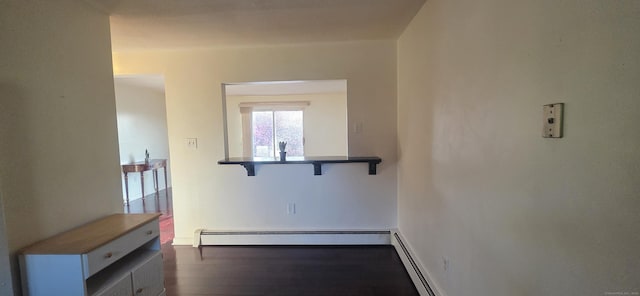 hallway with dark wood-style flooring and baseboard heating