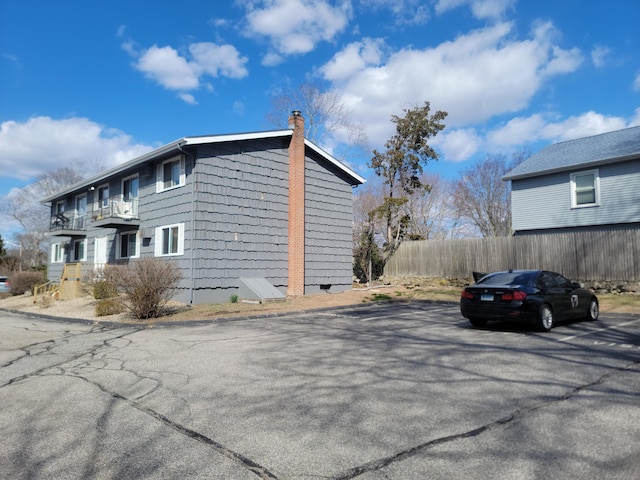 view of side of property with a chimney and fence