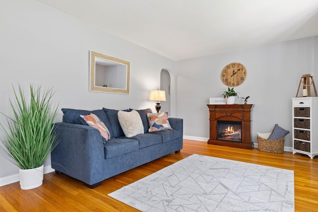 8 Dean Rd, East Lyme, CT 06333 - living area with arched walkways, a glass covered fireplace, and wood finished floors