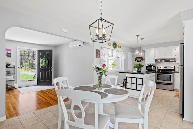 8 Dean Rd, East Lyme, CT 06333 - dining space featuring light tile patterned flooring, a chandelier, a wall mounted AC, and baseboards