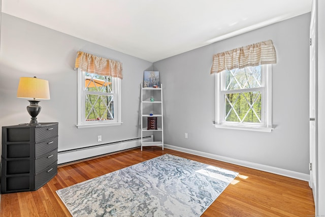 8 Dean Rd, East Lyme, CT 06333 - living area with a baseboard radiator, plenty of natural light, wood finished floors, and baseboards
