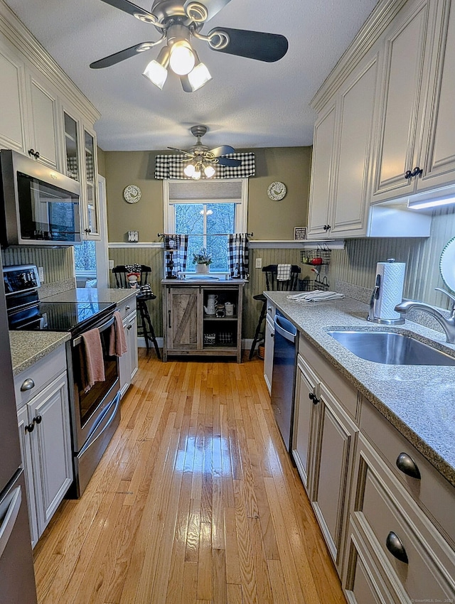 374 Heritage Vlg Unit C, Southbury, CT 06488 - kitchen with wainscoting, ceiling fan, a sink, light wood finished floors, and appliances with stainless steel finishes