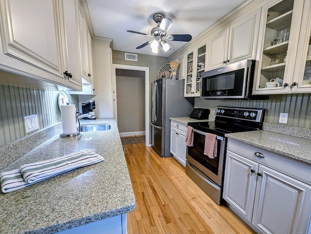 374 Heritage Vlg Unit C, Southbury, CT 06488 - kitchen with visible vents, glass insert cabinets, ceiling fan, light wood-style flooring, and stainless steel appliances