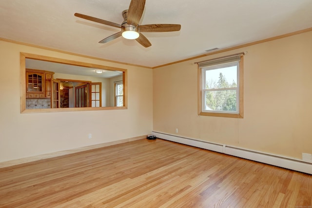 empty room featuring a baseboard heating unit, a ceiling fan, ornamental molding, and wood finished floors