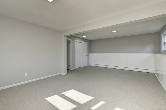 spare room with carpet, a baseboard heating unit, and baseboards