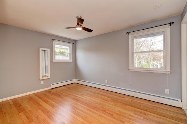 spare room with baseboards, wood finished floors, ceiling fan, and a baseboard heating unit