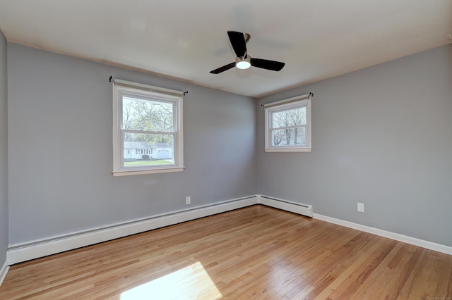 empty room featuring a baseboard heating unit, ceiling fan, baseboards, wood finished floors, and a baseboard radiator