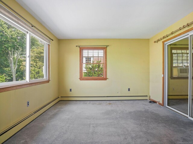 empty room with plenty of natural light, baseboard heating, a baseboard heating unit, and carpet floors