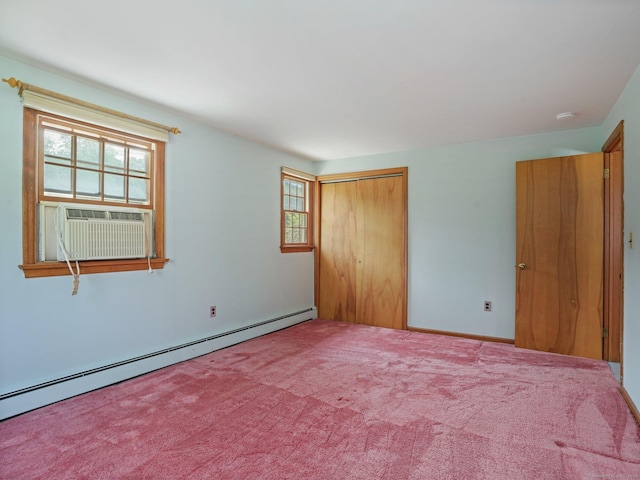 unfurnished bedroom with carpet floors, a closet, and a baseboard heating unit