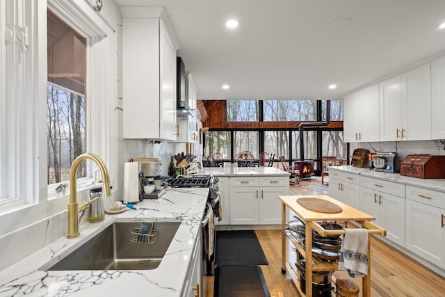 162 Hattertown Rd, Newtown, CT 06470 - kitchen with a sink, light wood-style floors, white cabinets, stainless steel gas range, and recessed lighting
