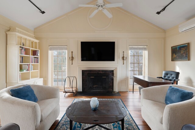 24-26 Lyme St, Old Lyme, CT 06371 - living area with track lighting, a fireplace, a ceiling fan, vaulted ceiling, and an AC wall unit