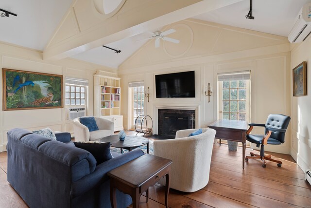 24-26 Lyme St, Old Lyme, CT 06371 - living area featuring a wall mounted air conditioner, a decorative wall, a glass covered fireplace, and a healthy amount of sunlight