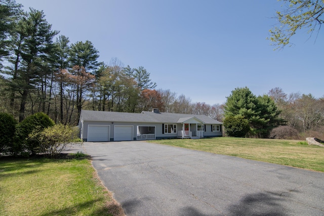 ranch-style home with a garage, a porch, driveway, and a front yard