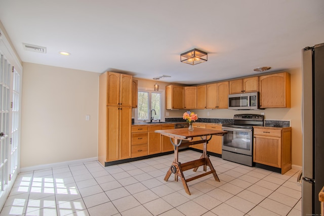 kitchen featuring visible vents, a sink, light tile patterned flooring, and stainless steel appliances