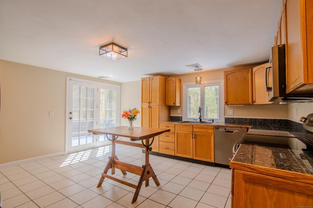 kitchen featuring electric range, a sink, tile countertops, stainless steel dishwasher, and visible vents