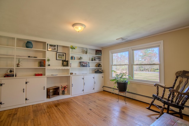 sitting room featuring crown molding, a baseboard radiator, light wood-type flooring, and visible vents