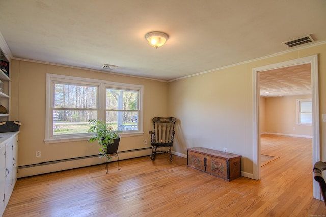 unfurnished room featuring visible vents, a baseboard heating unit, and light wood-type flooring