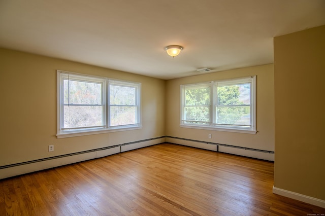 spare room with baseboards, wood finished floors, and visible vents
