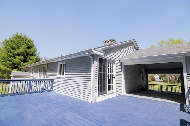 view of side of property featuring a deck and a chimney