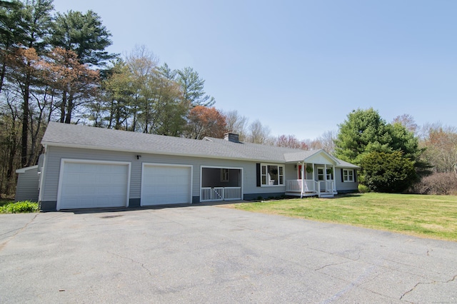 ranch-style house with aphalt driveway, a garage, a front yard, a chimney, and covered porch