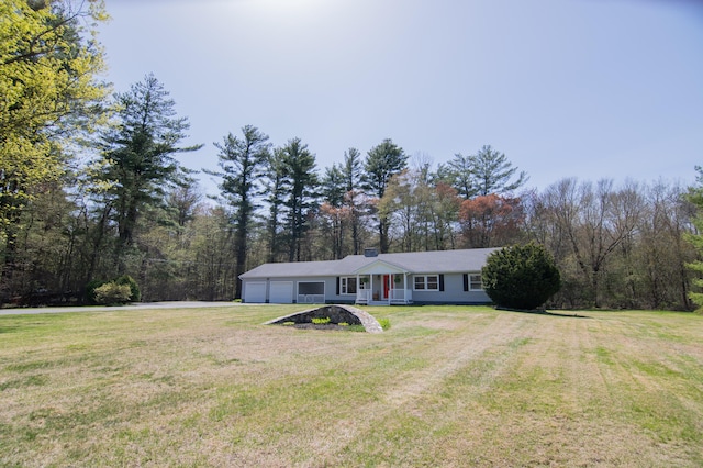 view of front of house with covered porch, driveway, a front yard, and a garage
